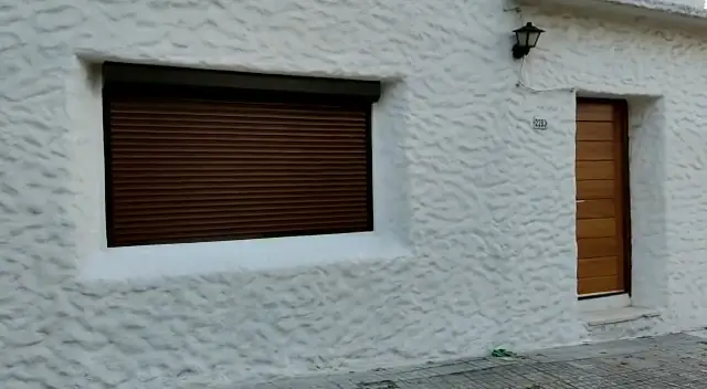 Cortina de enrollar color madera abriéndose en una ventana
