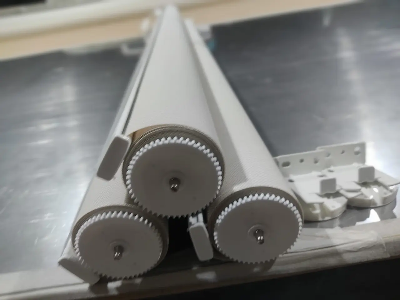 Tubos de cortinas roller con sus mecanismos de accionamiento, antes de la instalación