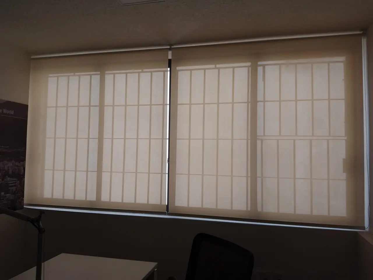 Cortinas roller screen cerradas en una ventana con reja, vistas desde el interior