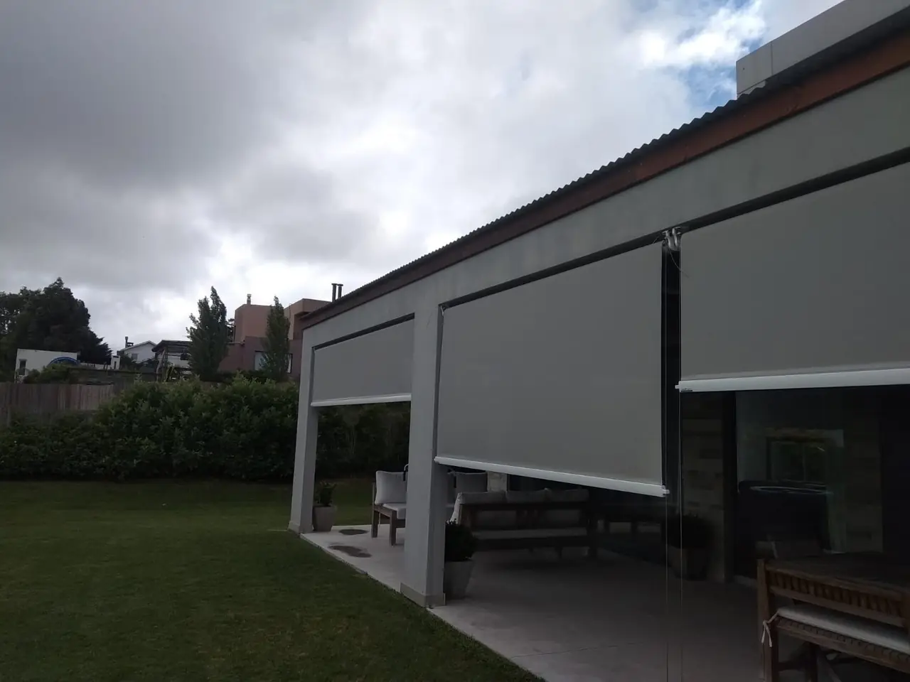 Toldos verticales bajados en una galería abierta al jardín