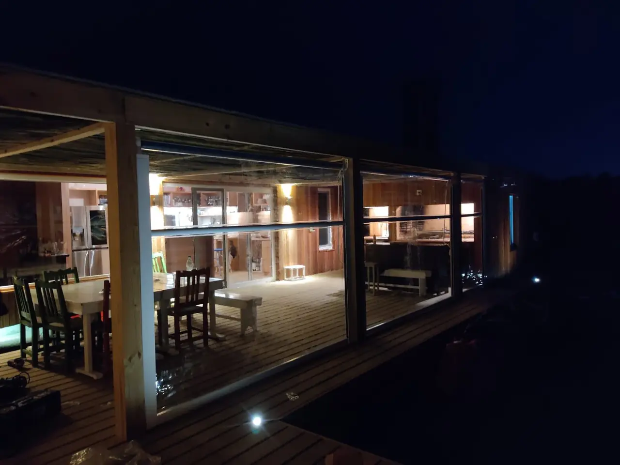 Galería con cerramientos de PVC iluminada de noche