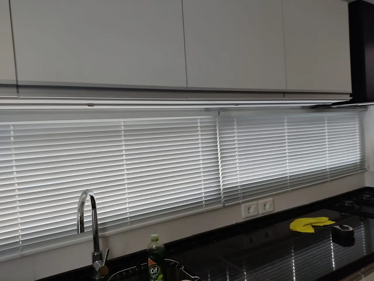 Cortina veneciana blanca a lo largo de la ventana de una cocina