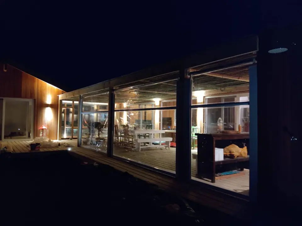 Galería cerrada con cerramientos de PVC transparente de noche