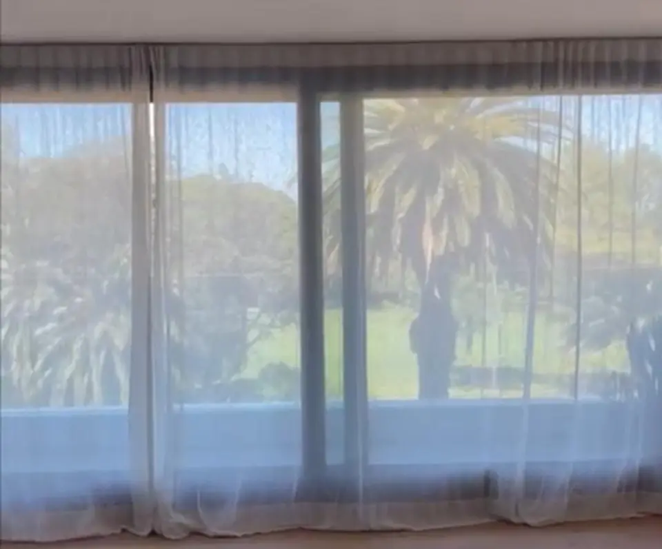 Cortinas tradicionales abiertas a ambos lados de una ventana